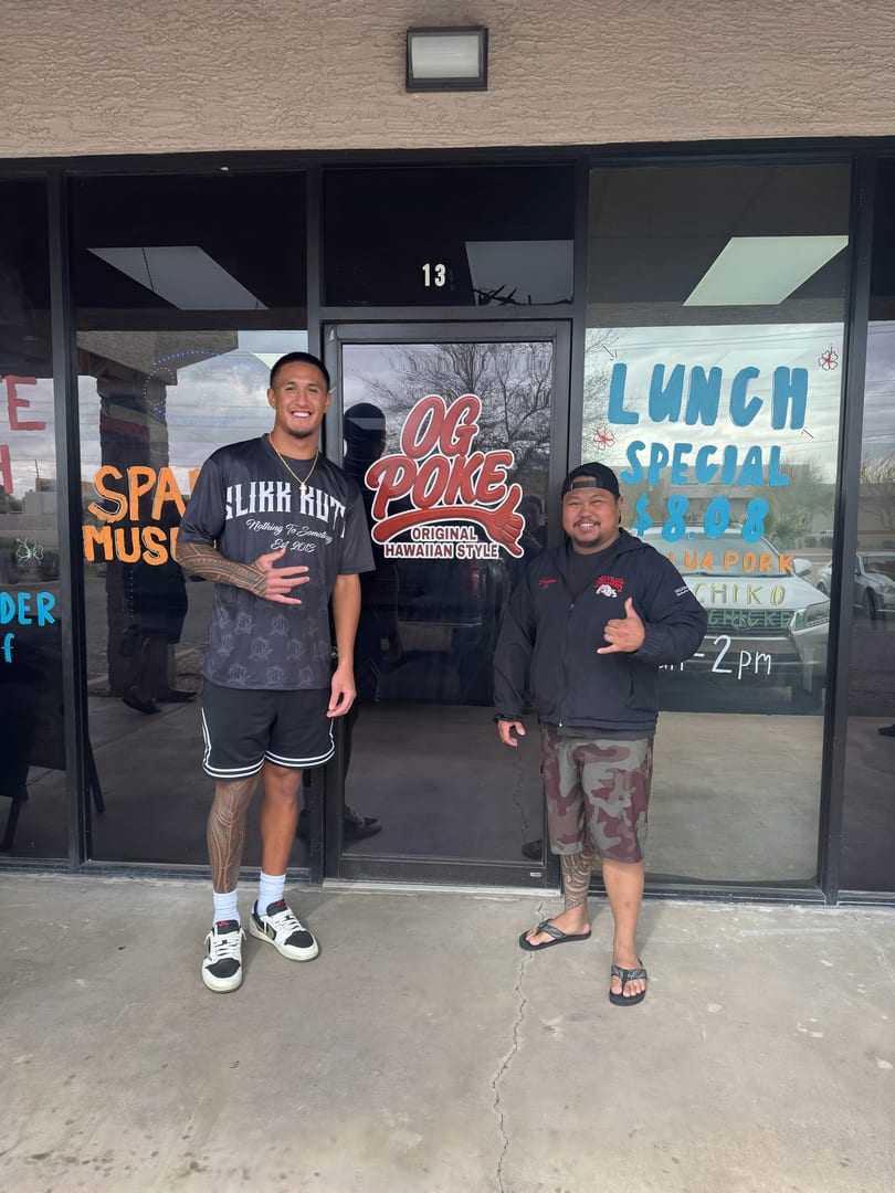 Two men stand outside OG Poke, a Hawaiian-style restaurant, with a "Lunch Special" sign visible.